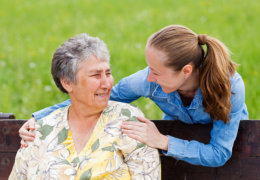 Smiling caregivers and old woman